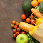 Bolsa de papel com frutas, legumes e pão sobre fundo rústico