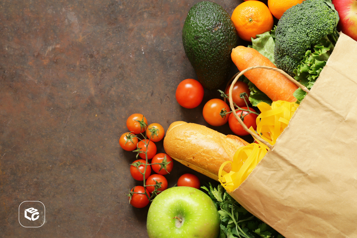 Bolsa de papel com frutas, legumes e pão sobre fundo rústico